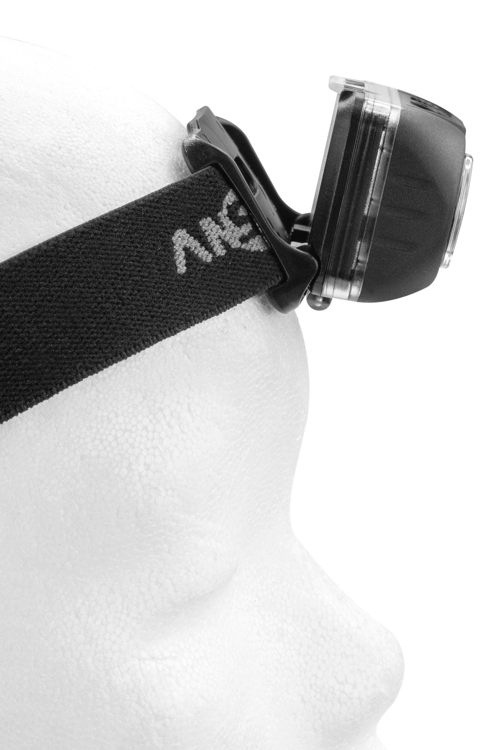 Ein weißer Modellkopf trägt eine schwarze Stirnlampe. Die Lampe ist in seitlicher Ansicht sichtbar und an einem elastischen Band befestigt.