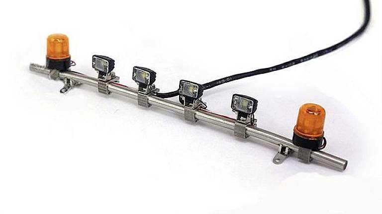 Eine Metallstange mit fünf LED-Leuchten und zwei orangefarbenen Warnlichtern, montiert an einem Kabel mit Befestigungsklemmen.