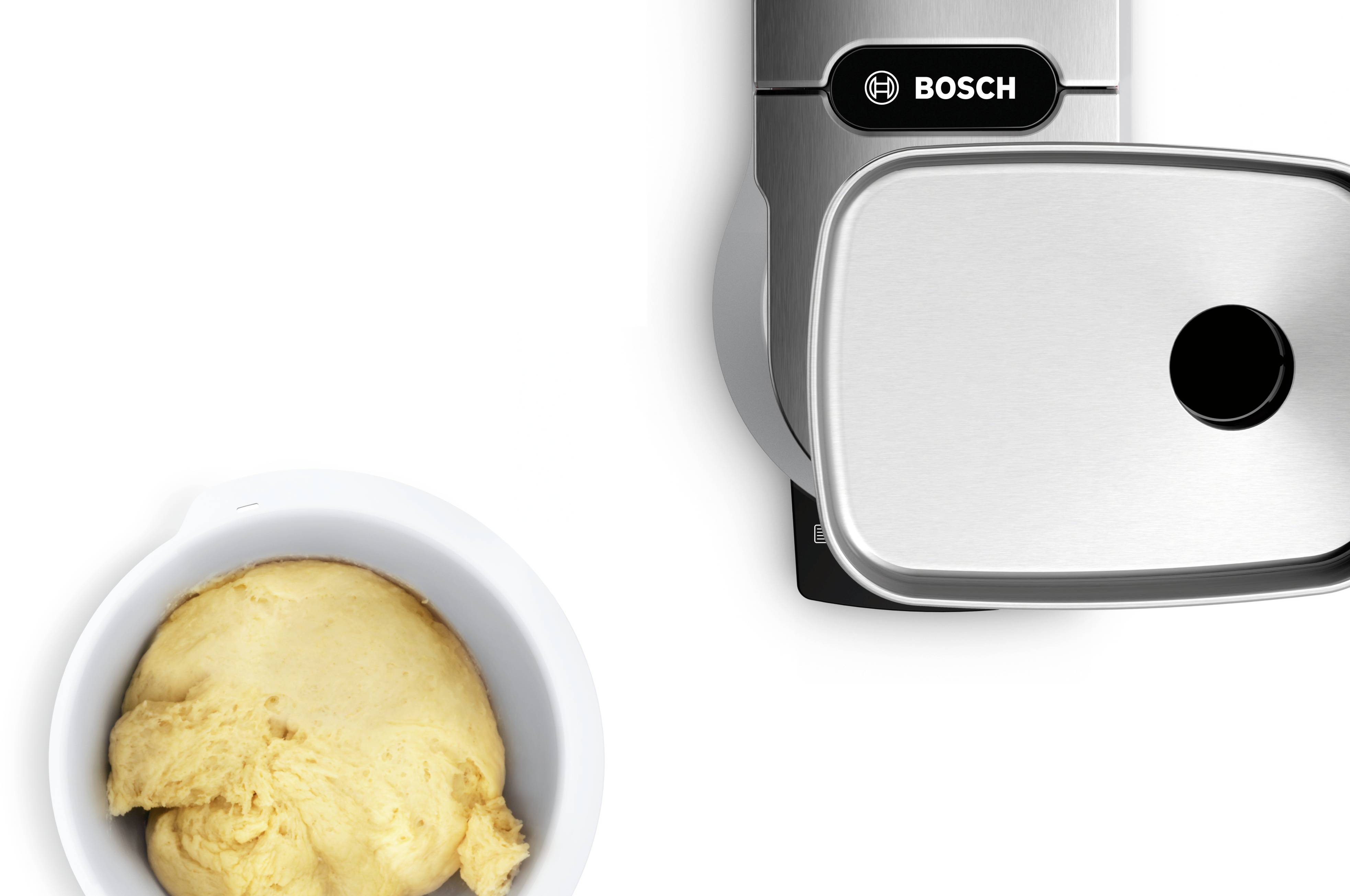 Teig in einer Schüssel neben einer modernen Küchenmaschine.