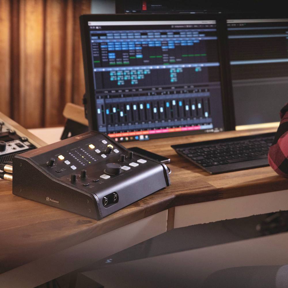 Tonstudio mit Mischpult, Computerbildschirmen und Tastatur. Audiosoftware zeigt Tonspuren und Steuerungen an.