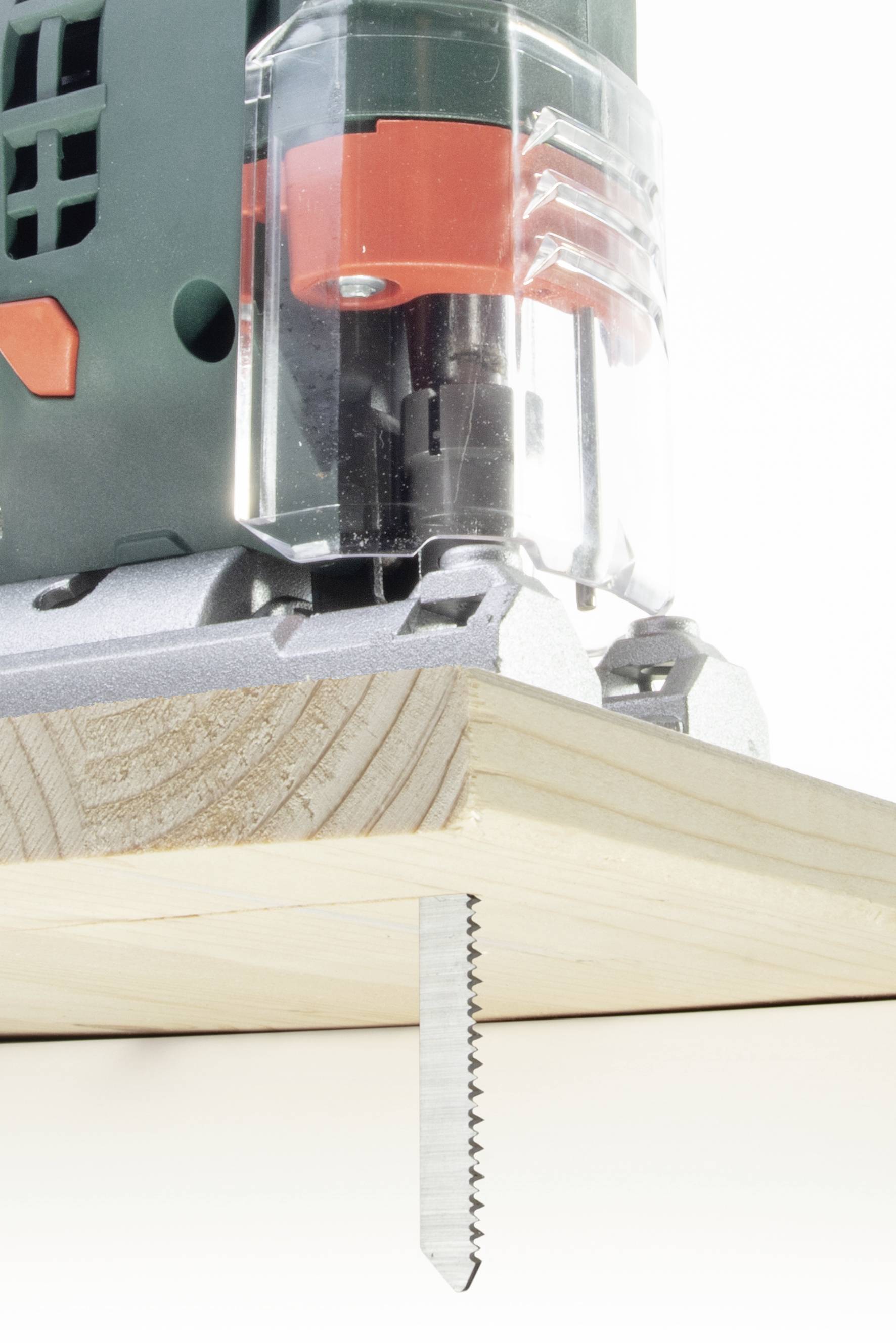 Akkustichsäge schneidet ein Stück Holz. Sägeblatt bewegt sich auf und ab und erzeugt gerade Schnitte.