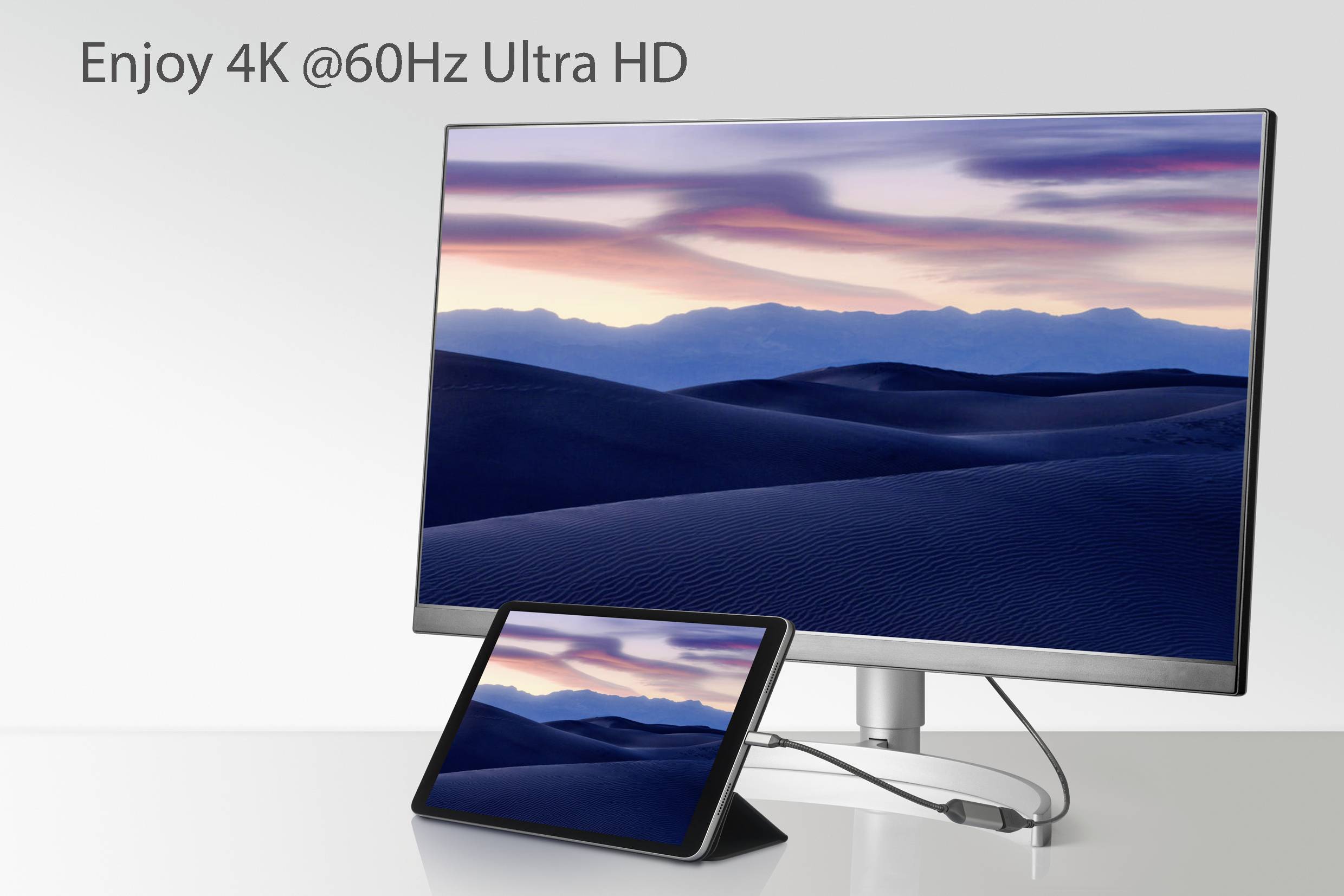 Ein Monitor und ein Tablet sind mit einem Kabel verbunden. Der Bildschirm zeigt eine Wüstenlandschaft bei Sonnenuntergang. Text: 'Enjoy 4K @60Hz Ultra HD'.