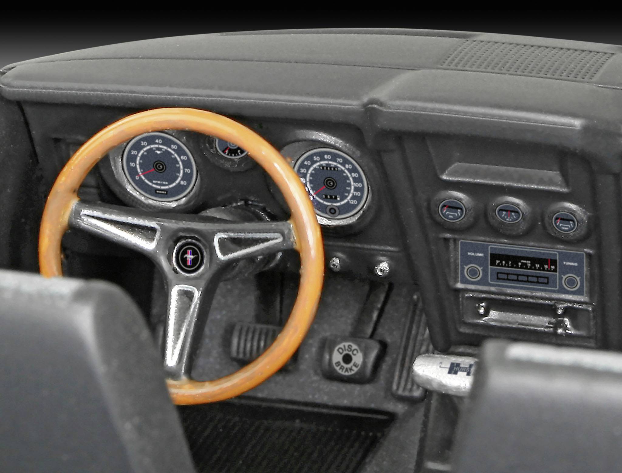 Nahaufnahme eines klassischen Auto-Cockpits mit Holzlenkrad, Armaturenbrett mit analogen Instrumenten und einem Retro-Autoradio.