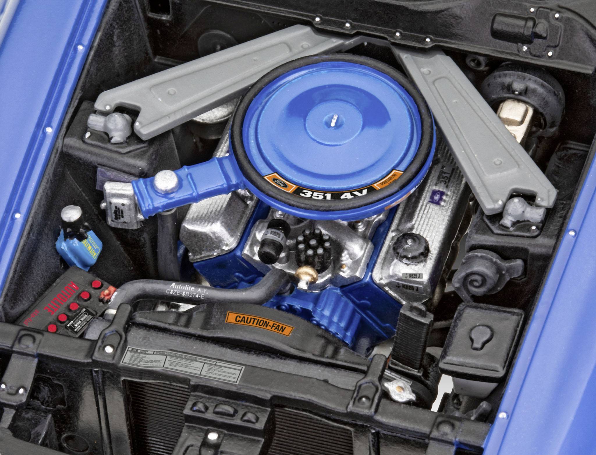 Ein Ford-Motorraum mit einem blauen Luftfilter und der Aufschrift '351 4V'. Zahlreiche Kabel und mechanische Teile sind sichtbar.