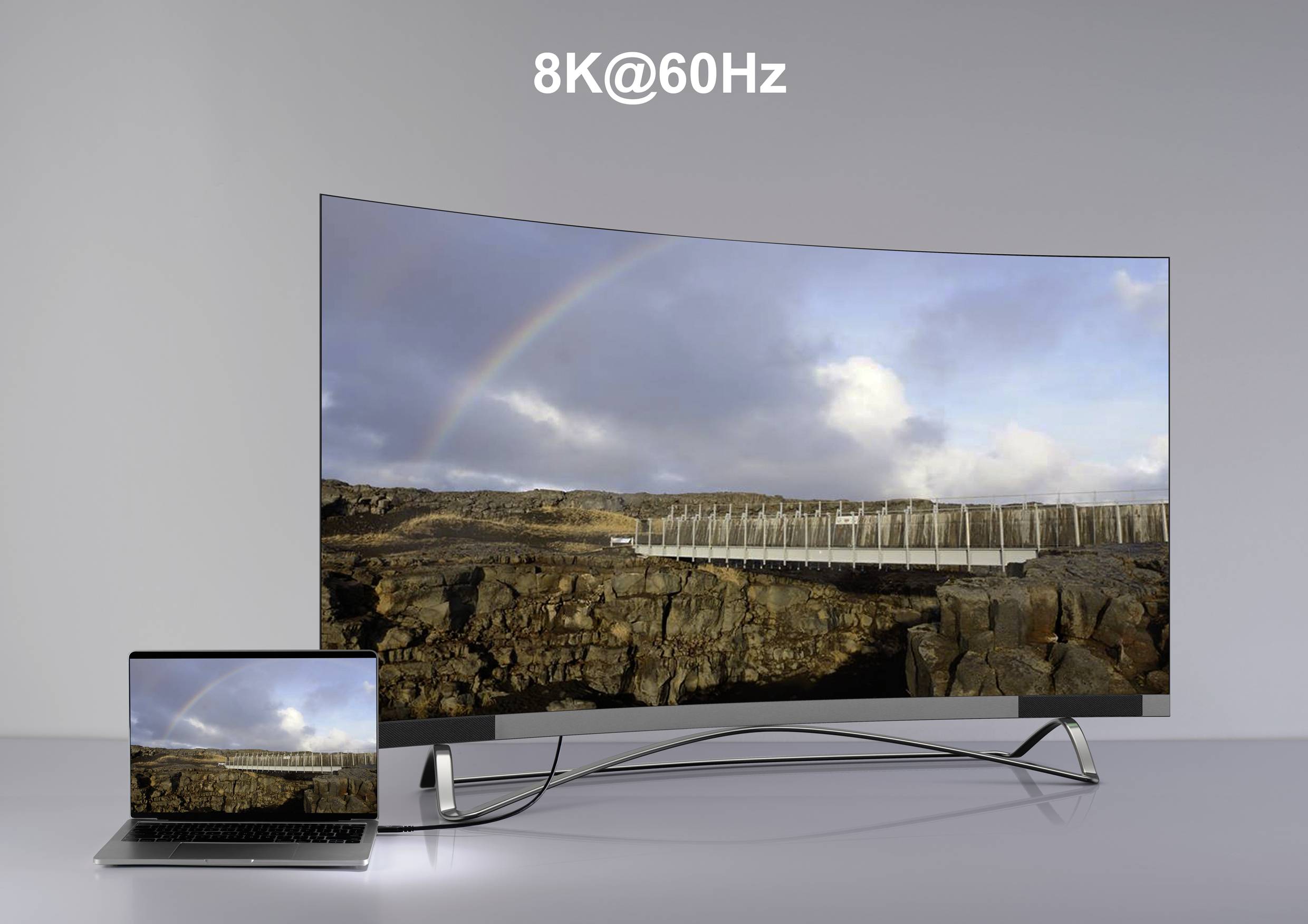 Großer gebogener 8K-Fernseher zeigt Bild einer Landschaft mit Regenbogen, verbunden mit einem Laptop, das dasselbe Bild anzeigt.