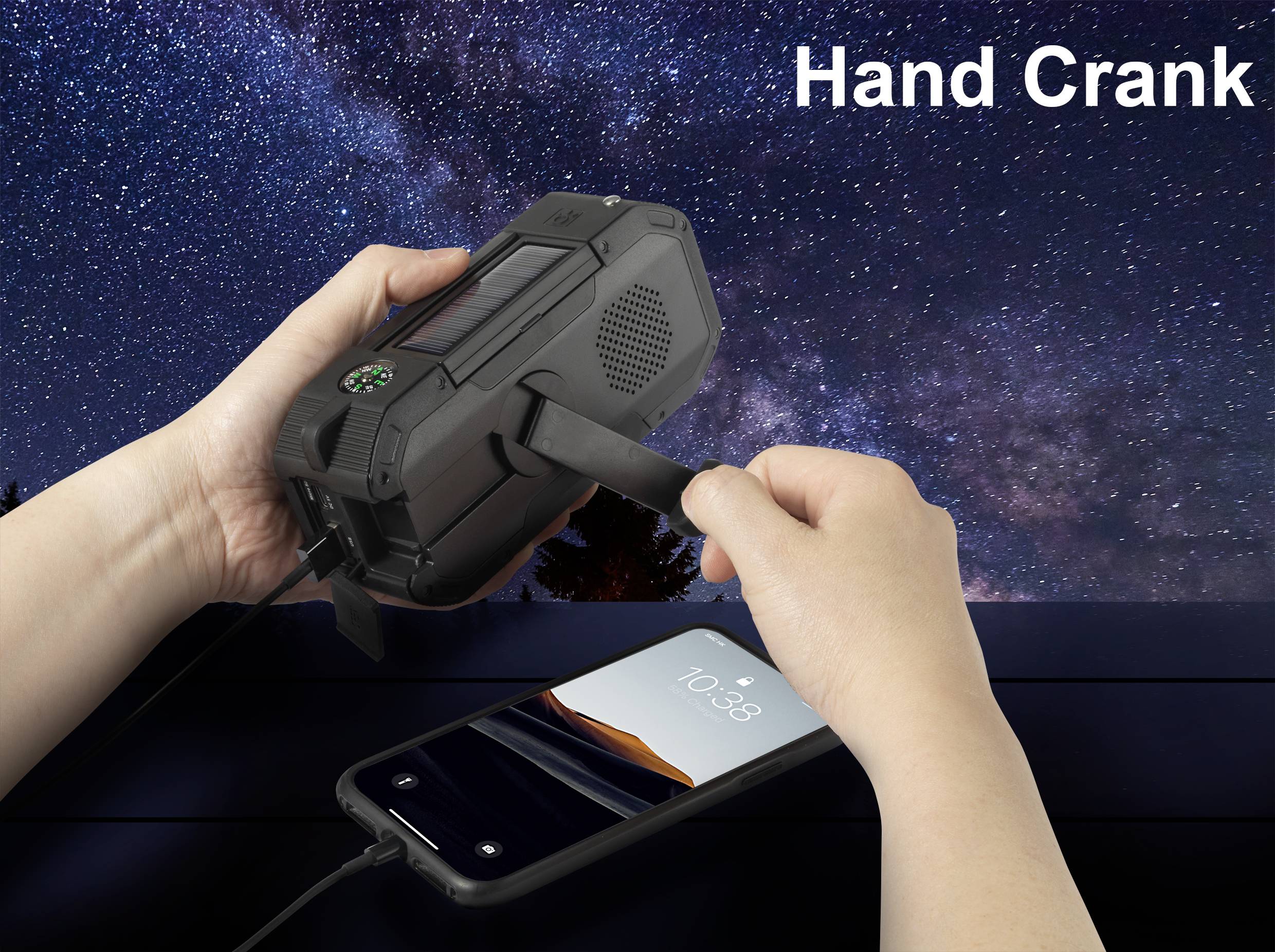 Eine Person nutzt eine Kurbel an einem schwarzen, tragbaren Gerät, um ein Smartphone aufzuladen. Der Nachthimmel ist im Hintergrund sichtbar.
