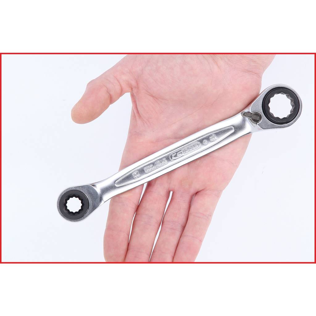 Eine Hand hält einen silbernen Ringschlüssel mit zwei Größen. Der Hintergrund ist weiß, der Ringschlüssel reflektiert Licht.