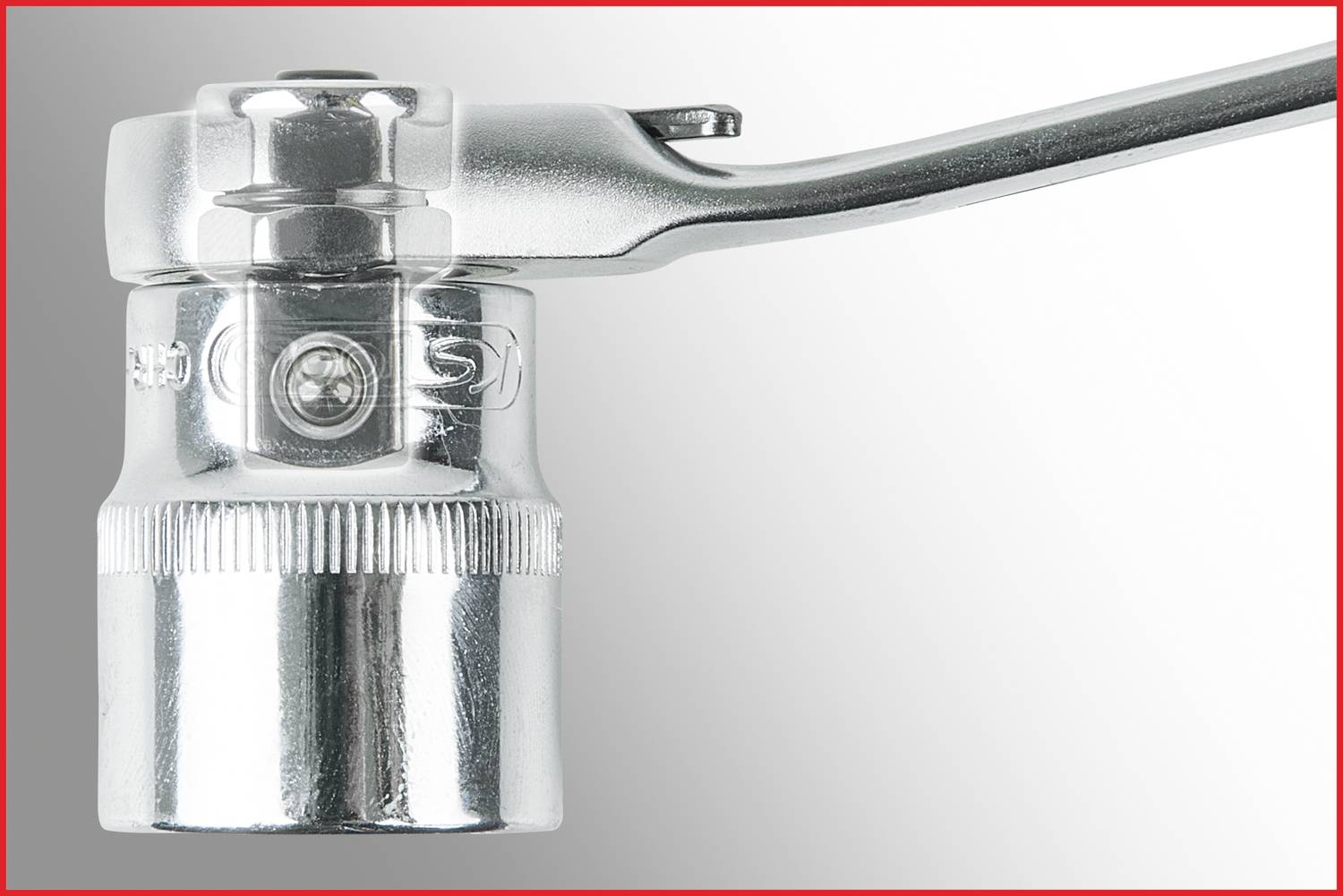 Nahaufnahme eines silbernen Steckschlüssels mit rotem Rahmen. Der Kopf ist gerastert für besseren Halt. Die Oberfläche ist glänzend und metallisch.