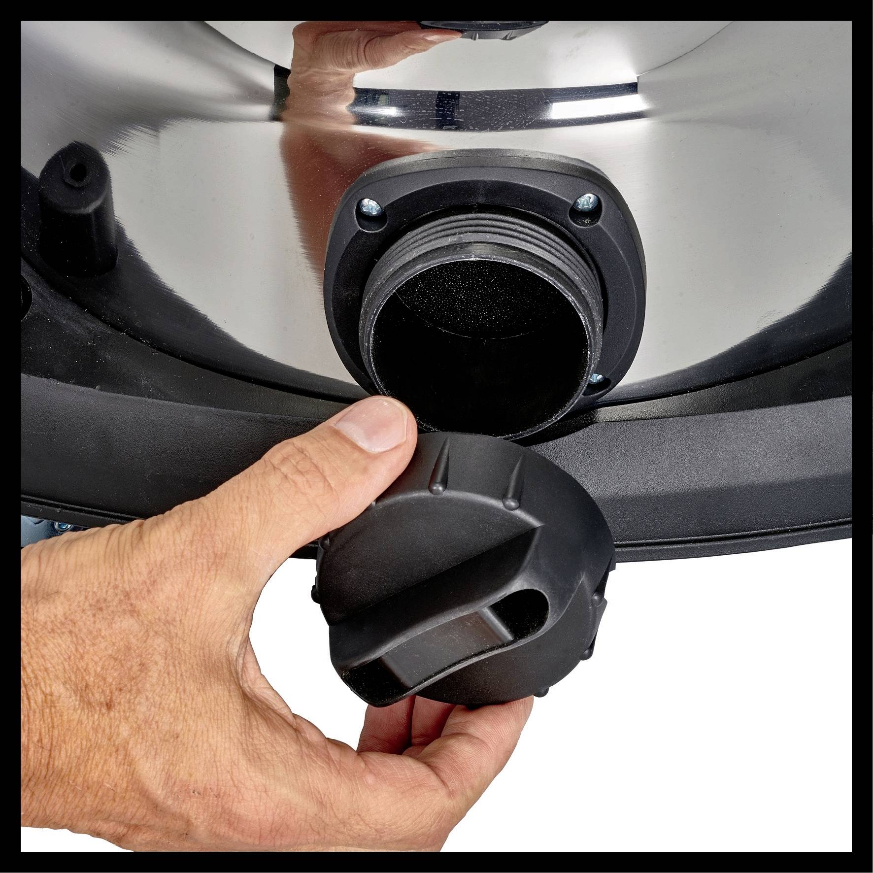 Eine Hand schließt den Deckel auf einer Metallöffnung.