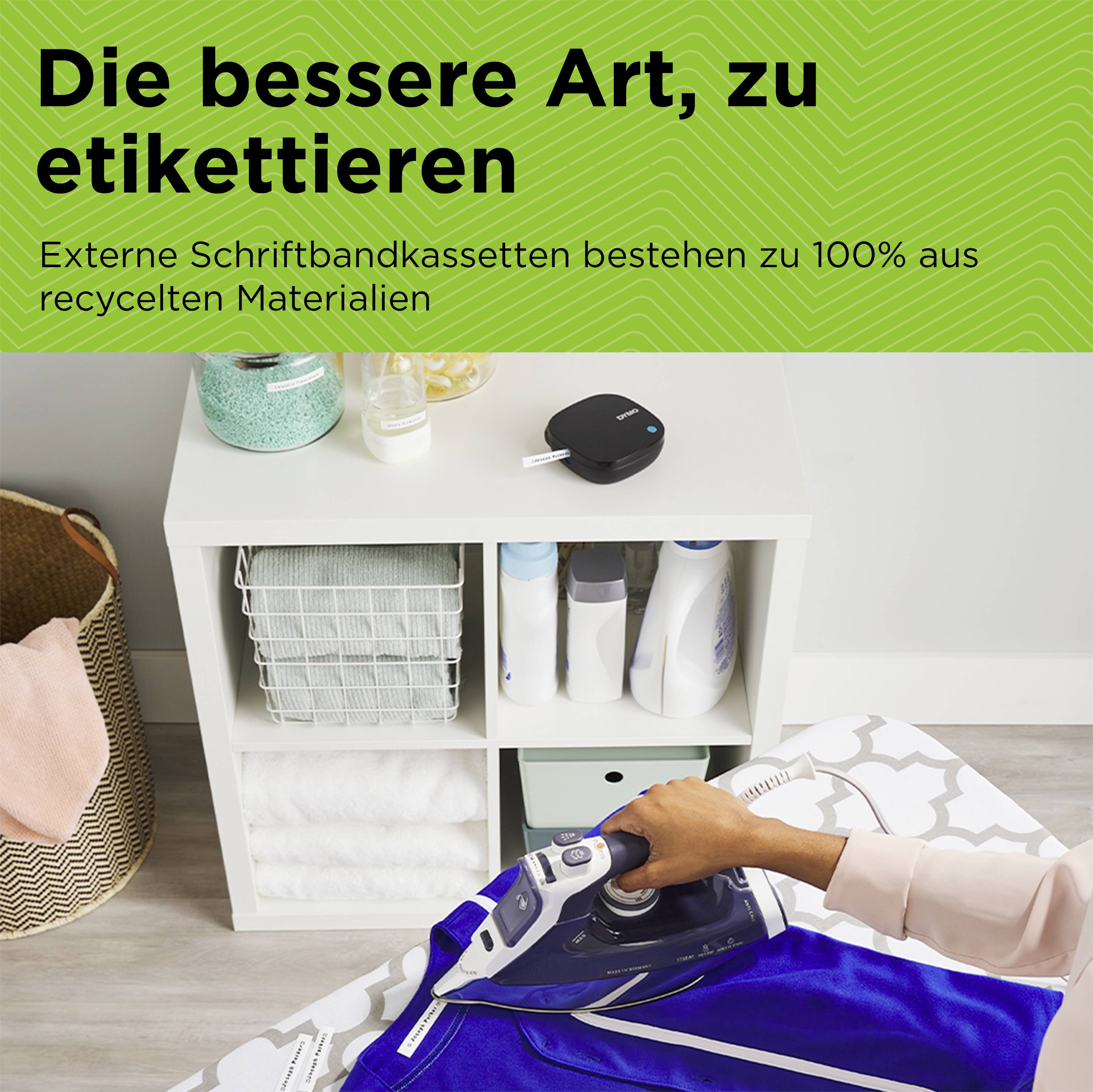 Eine Person bügelt ein geschwungenes, blaues Hemd. Oberhalb steht: 'Die bessere Art, zu etikettieren'. Ein Regal mit Haushaltsutensilien im Hintergrund.