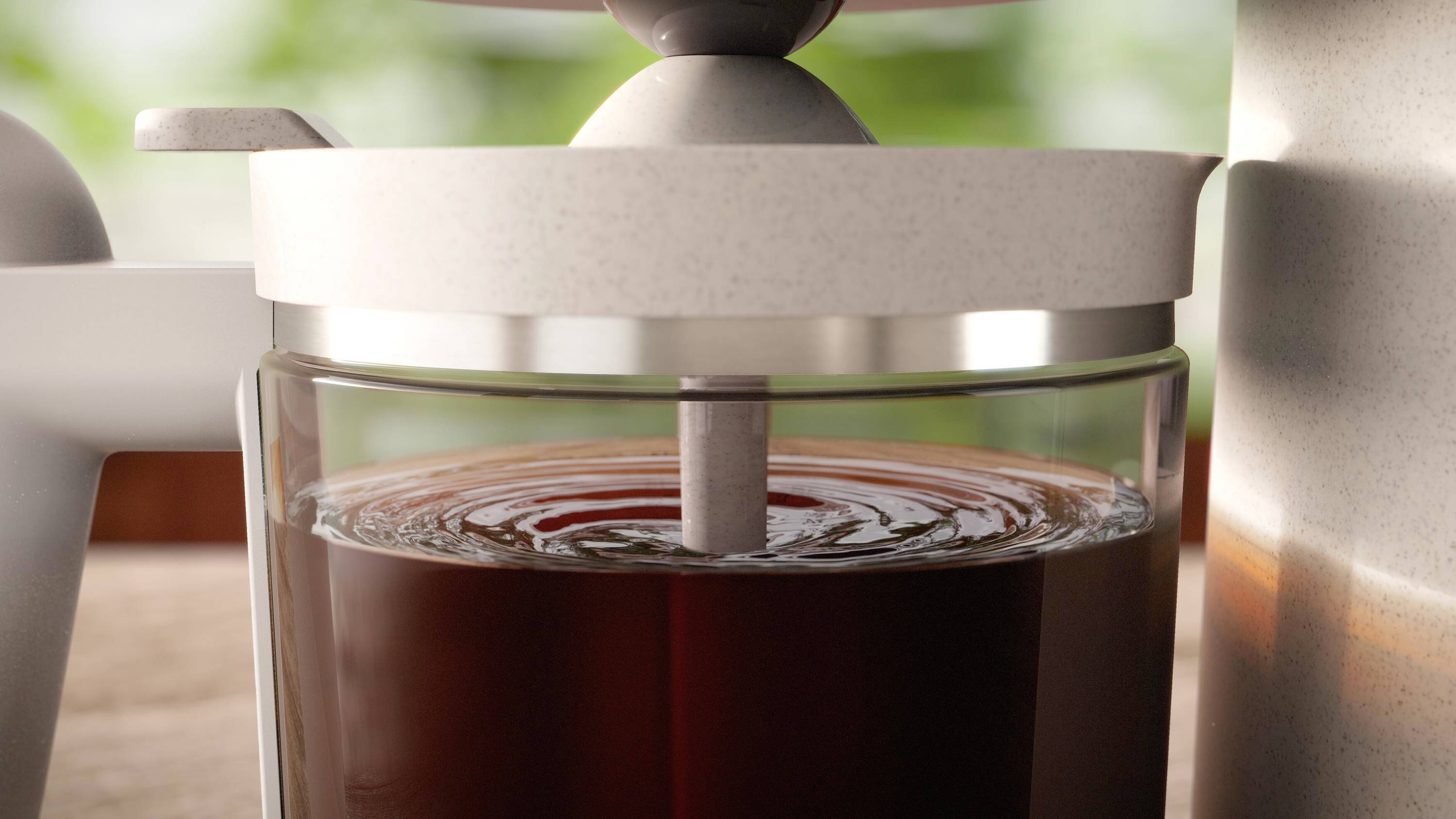 Nahaufnahme einer Kaffeepresse mit frisch aufgebrühtem Kaffee, der stufenweise durch einen Filter nach unten gedrückt wird.