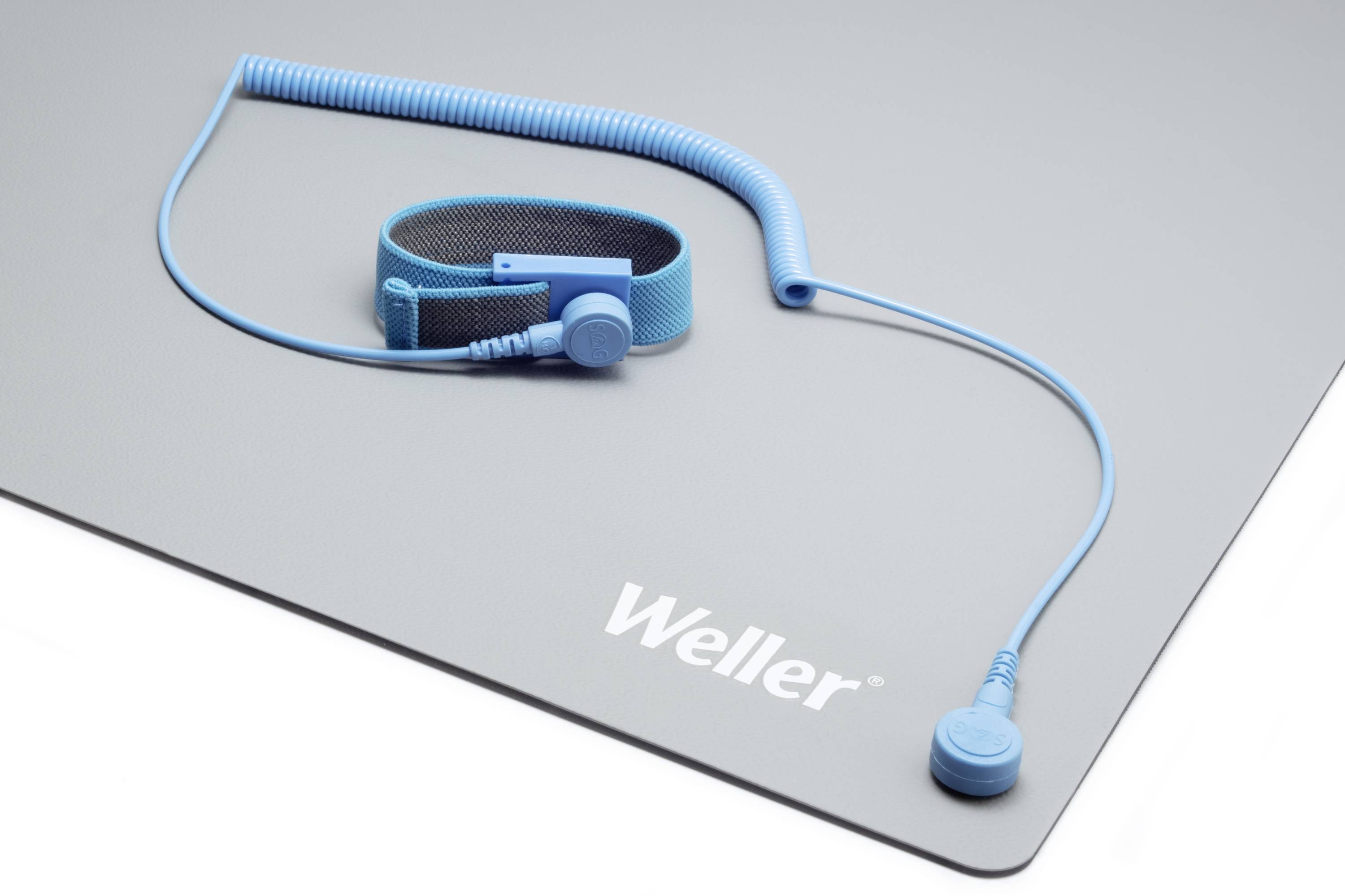 Blaues Erdungskabel und Armband auf grauer Matte mit 'Weller'-Logo. Wird für statische Entladungsschutz verwendet.