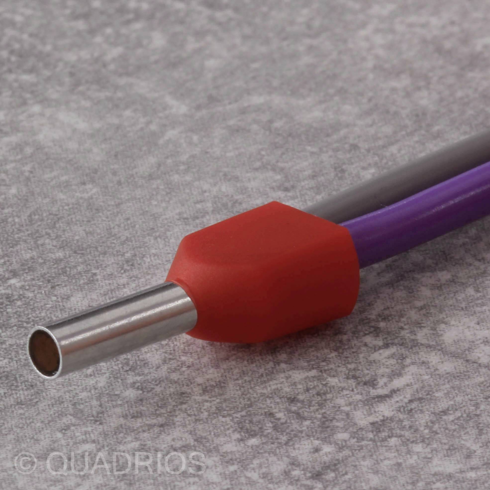 Ein silbernes Metallrohr mit einem roten, sechseckigen Kunststoffgriff und einem violetten Kabel auf einer grauen Oberfläche.