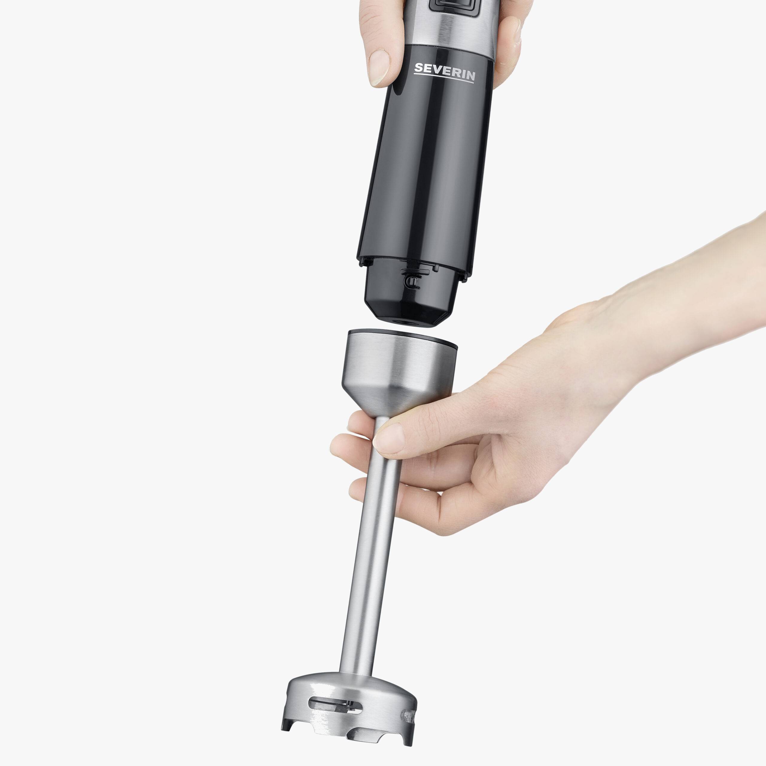 Eine Hand hält einen schwarzen Stabmixer-Behälter und steckt den Mixaufsatz an, um das Gerät zusammenzusetzen.