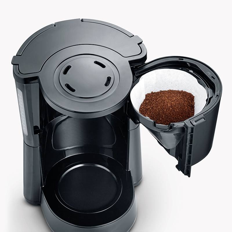 Kaffeemaschine mit geöffnetem Filterhalter, der frisches Kaffeepulver zeigt. Essentiell für Zubereitung frischen Filterkaffees.
