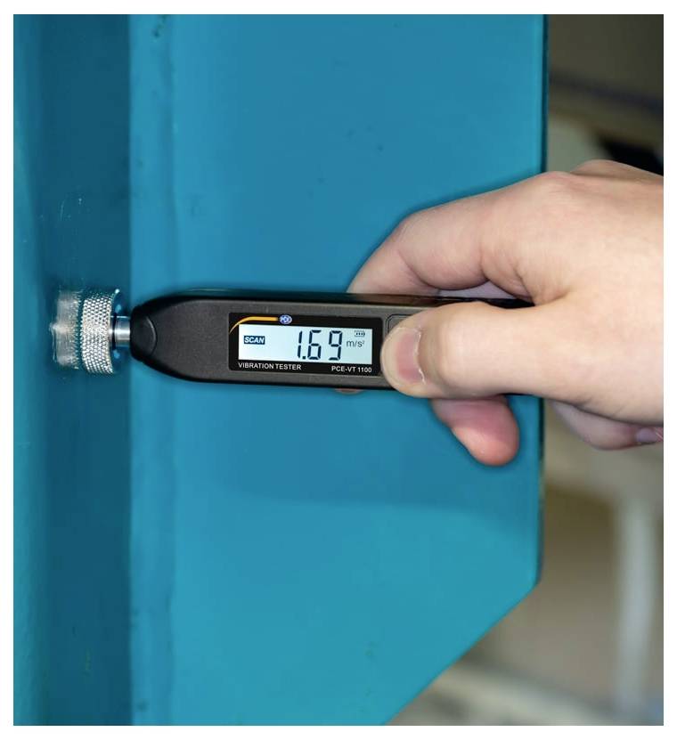 Tragbares Vibrationsmessgerät, das eine blaue Metalloberfläche misst und einen Messwert von 1,69 mm/s auf seinem digitalen Display anzeigt.