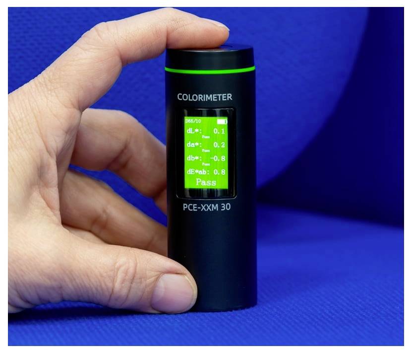 Hand, die einen schwarzen Kolorimeter hält, der einen grünen 