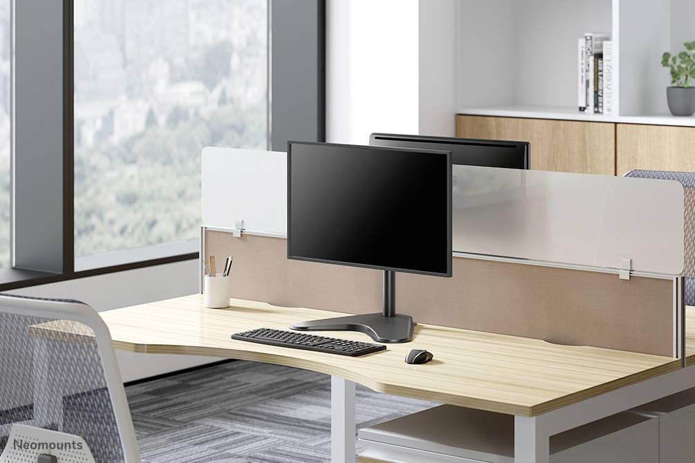 Ein modernes Büro mit zwei Arbeitsplätzen an einem Schreibtisch, je mit Monitor, Tastatur und Maus. Große Fenster bieten Ausblick.