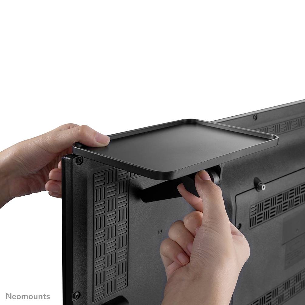 Hände montieren ein flaches Regal an die Rückseite eines Monitors oder Fernsehers.