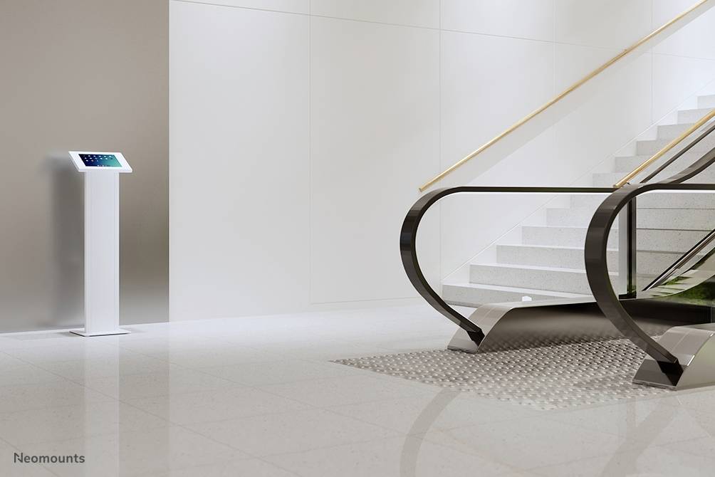 Lobby mit Rolltreppe und Treppe; Infoterminal links zeigt Bildschirm mit digitalen Informationen an.