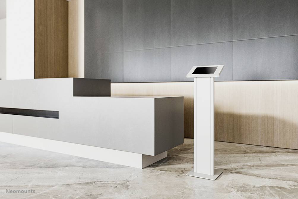 Moderne Empfangshalle mit grauem Tresen und freistehendem Infoterminal, das für interaktive Informationszugriffe genutzt wird.