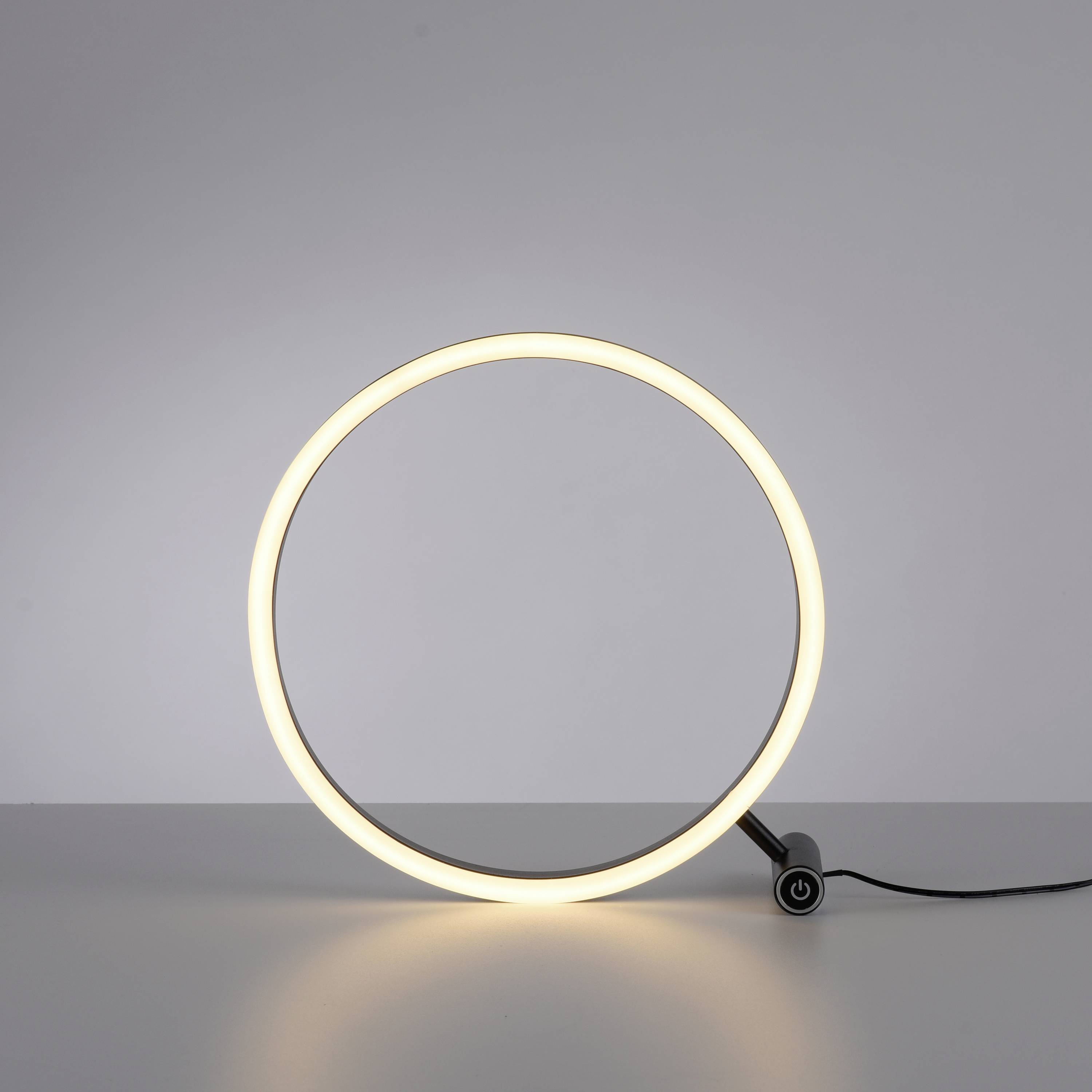 Ein stilvolles, rundes LED-Licht auf einem Tisch leuchtet hell und gleichmäßig in einem minimalistisch gestalteten Raum.