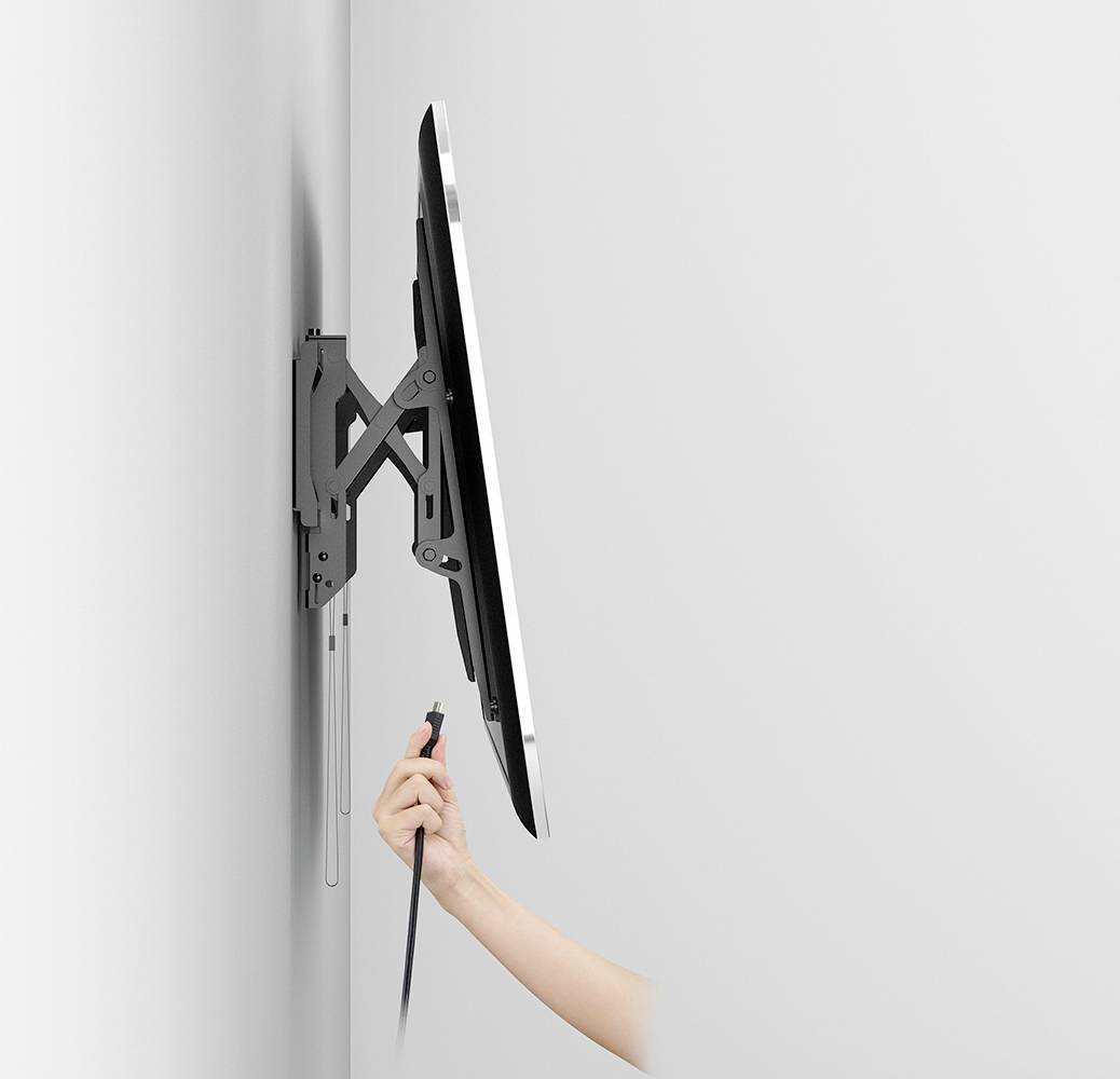 Abgebildet ist ein an der Wand montierter Monitor, der von einer Hand mit einem Kabel verbunden wird.