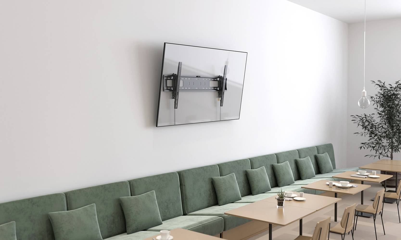 Ein Besprechungsraum mit einer langen grünen Couch, Holztischen und einem großen, an der Wand montierten Flachbildschirm.