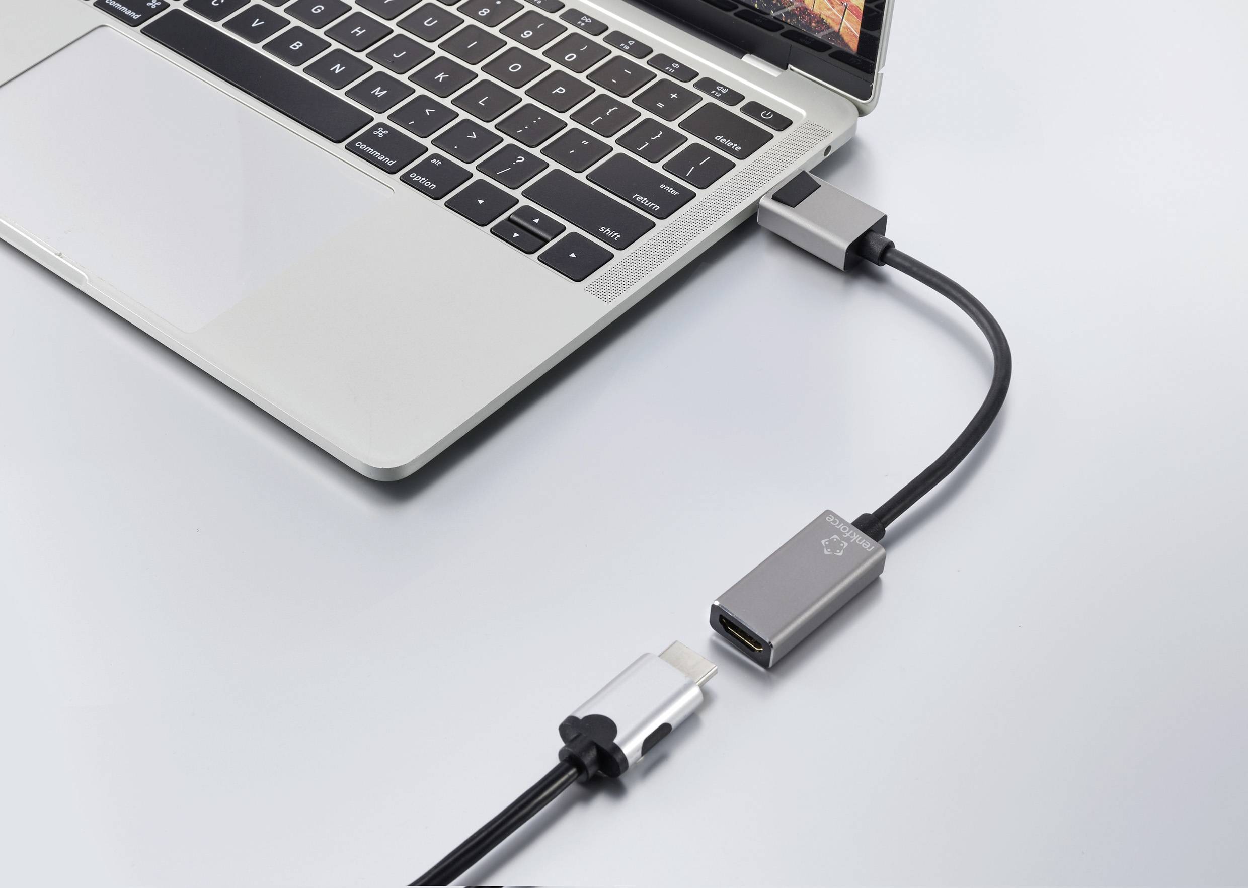 Ein Laptop mit einem HDMI-Adapter, der an einen USB-C-Anschluss angeschlossen ist. Ein HDMI-Kabel ist an den Adapter angeschlossen.