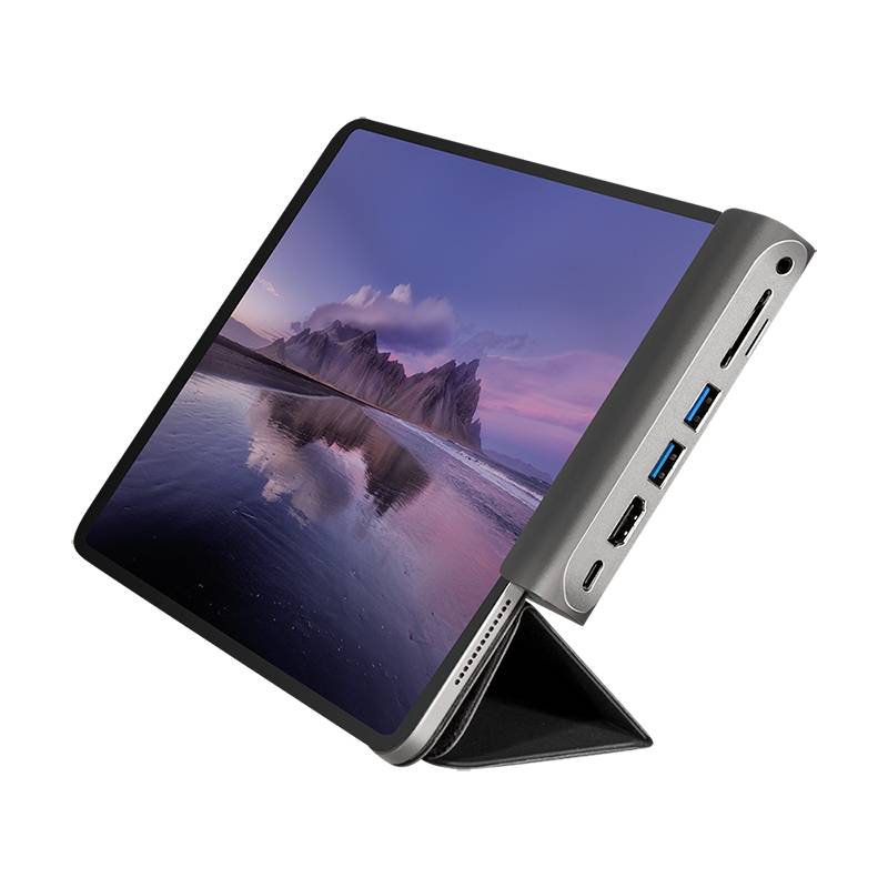 Ein Tablet mit schützendem Gehäuse zeigt eine Strandlandschaft bei Sonnenuntergang. Anschlüsse sind seitlich am Gehäuse sichtbar.