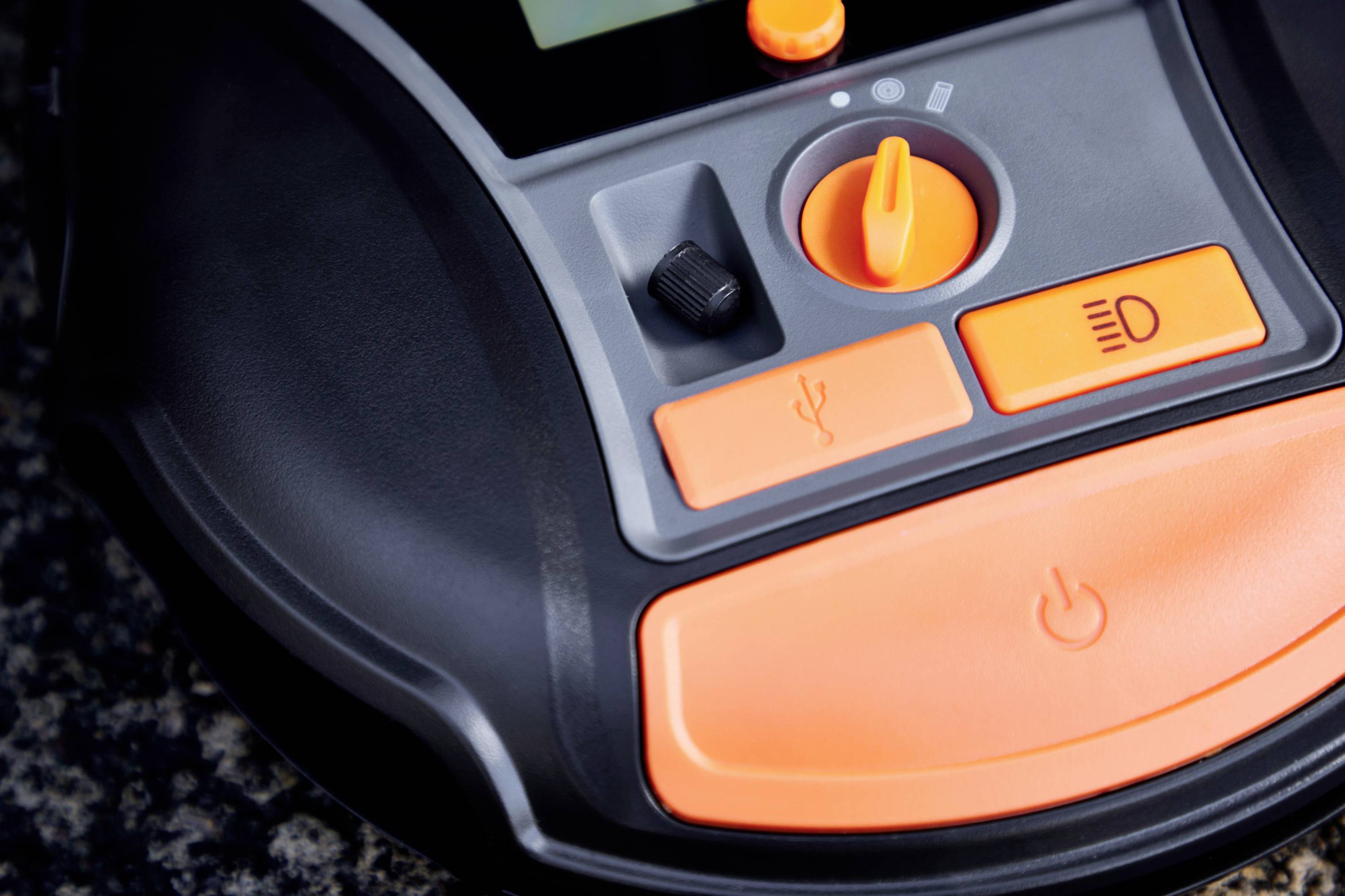 Ein Nahaufnahme eines elektronischen Bedienfelds mit orangefarbenen Tasten und einem Drehschalter, möglicherweise Teil eines Geräts.