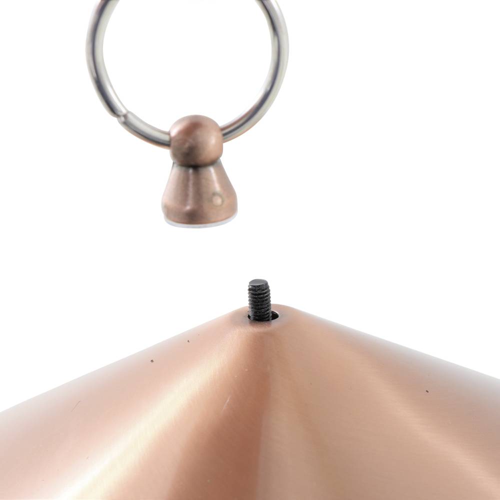 Ein metallischer Lampenschirm wird von einem Haken gehalten. Oben ist ein kleiner Knauf sichtbar, der an einer Schraube befestigt ist.