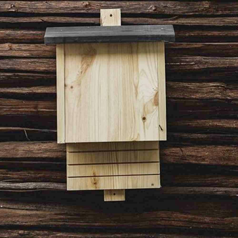 Holz-Nistkasten für Fledermäuse an einer braunen Holzwand montiert.