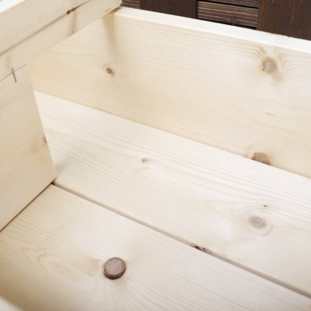 Ein offener Holzkasten aus hellem Holz mit sichtbaren Maserungen, ohne Inhalt, steht auf einem Holzboden.