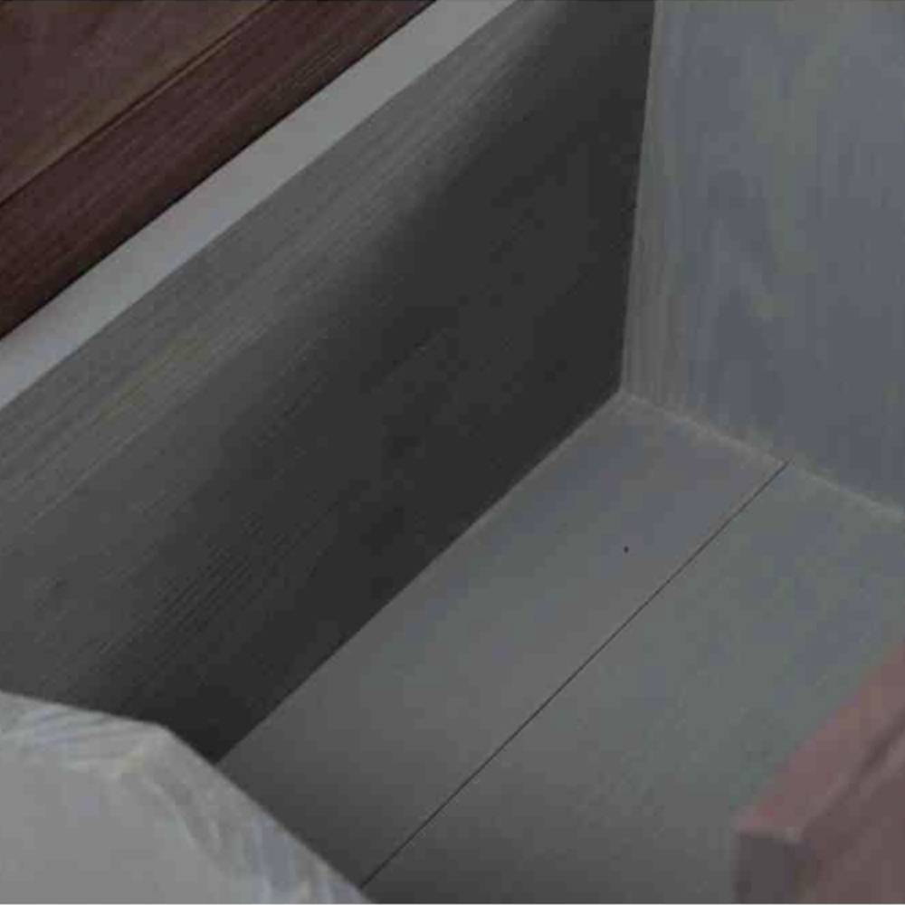 Eine leere, geöffnete Schublade aus Holz in einem Möbelstück, von oben fotografiert. Schlichte, moderne Gestaltung.