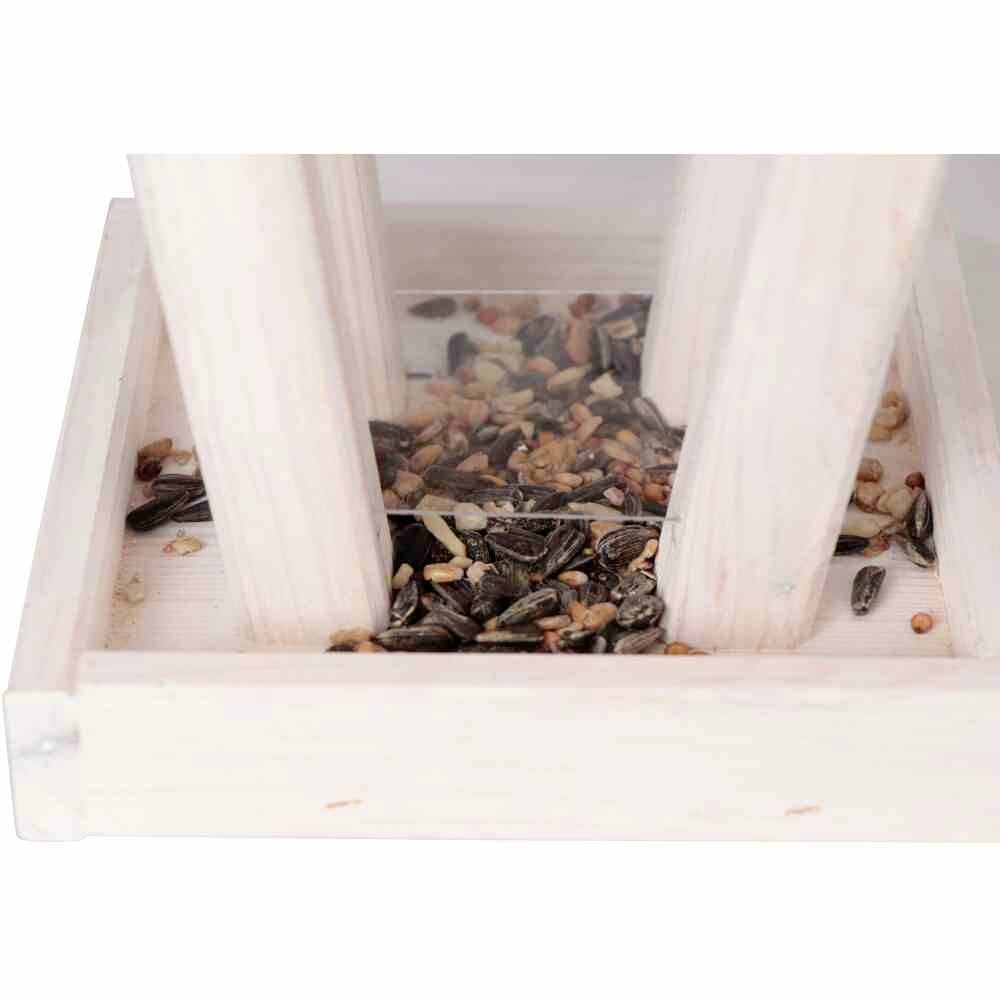 Ein Holzkasten mit zwei senkrechten Wänden und Vogelfutter aus Sonnenblumenkernen und Körnern am Boden.