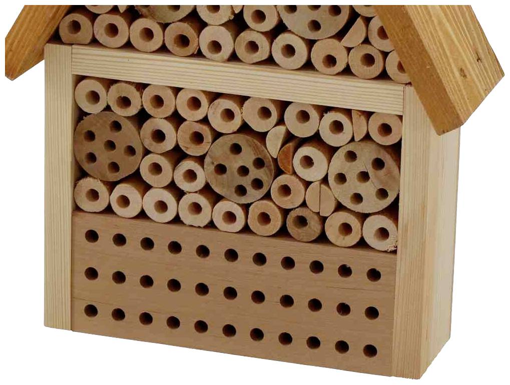 Ein Insektenhotel mit verschiedenen großen Löchern in einem Holzrahmen, das Nistmöglichkeiten für Wildbienen bietet.