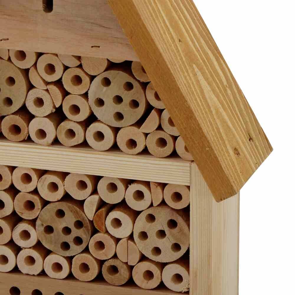 Ein Insektenhotel mit Holzscheiben und Löchern, das als Unterschlupf für Wildbienen und andere nützliche Insekten dient.