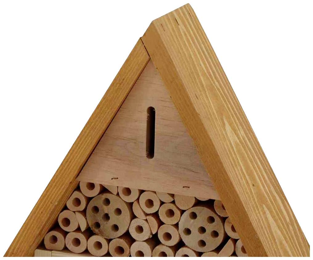 Ein Insektenhotel mit mehreren Löchern in Holzscheiben bietet Unterschlupf für Bienen und andere bestäubende Insekten.