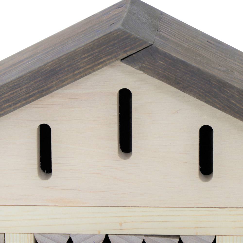 Ein Holzdach mit drei ovalen Lüftungsschlitzen, Teil eines größeren Holzobjekts.