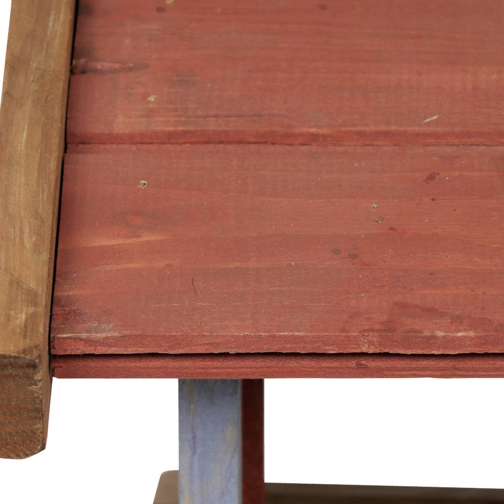 Nahaufnahme eines Holztisches mit rotbrauner Oberfläche und blauer Beinseite.