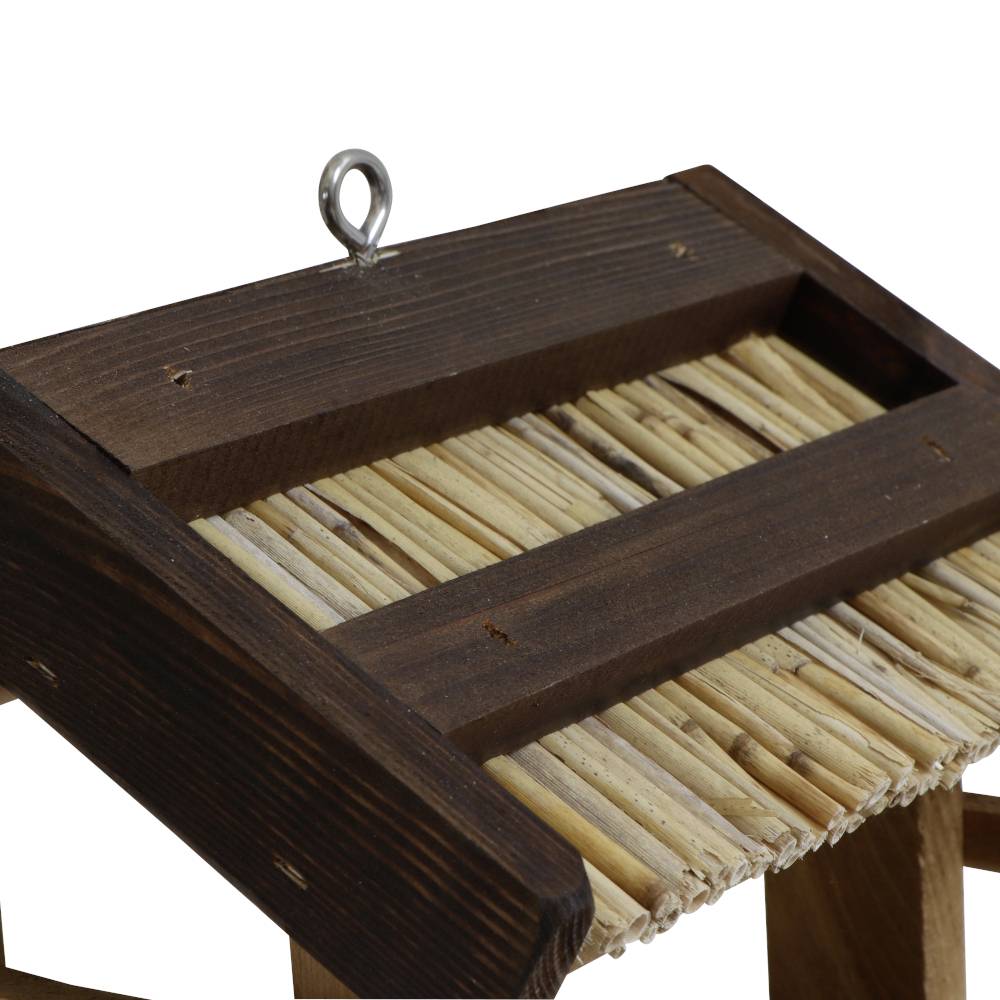 Holz-Vogelfutterhaus mit Schilfabdeckung und Metallring oben zur Aufhängung. Rustikales Design, geeignet für Gärten oder Balkone.