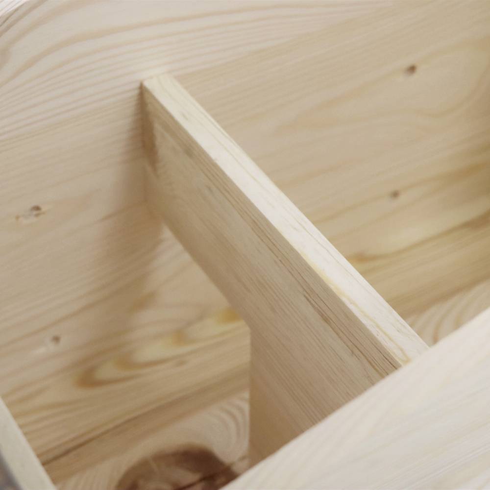 Ein unfertiges Holzmöbelstück, möglicherweise ein Regal, zeigt eine Nahaufnahme von hellem Holz mit sichtbarer Maserung und Verbindungselementen.