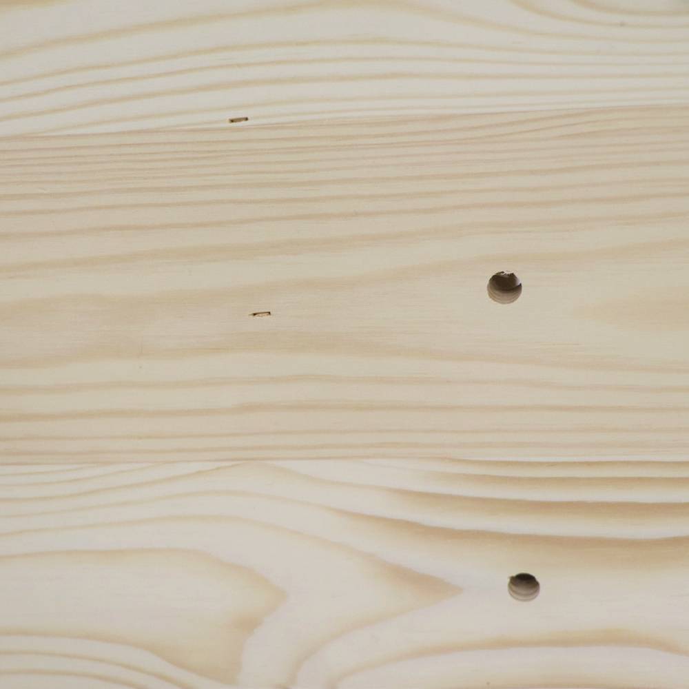 Eine glatte Holzoberfläche mit sichtbarer Maserung und zwei kleinen Löchern, die symmetrisch angeordnet sind.