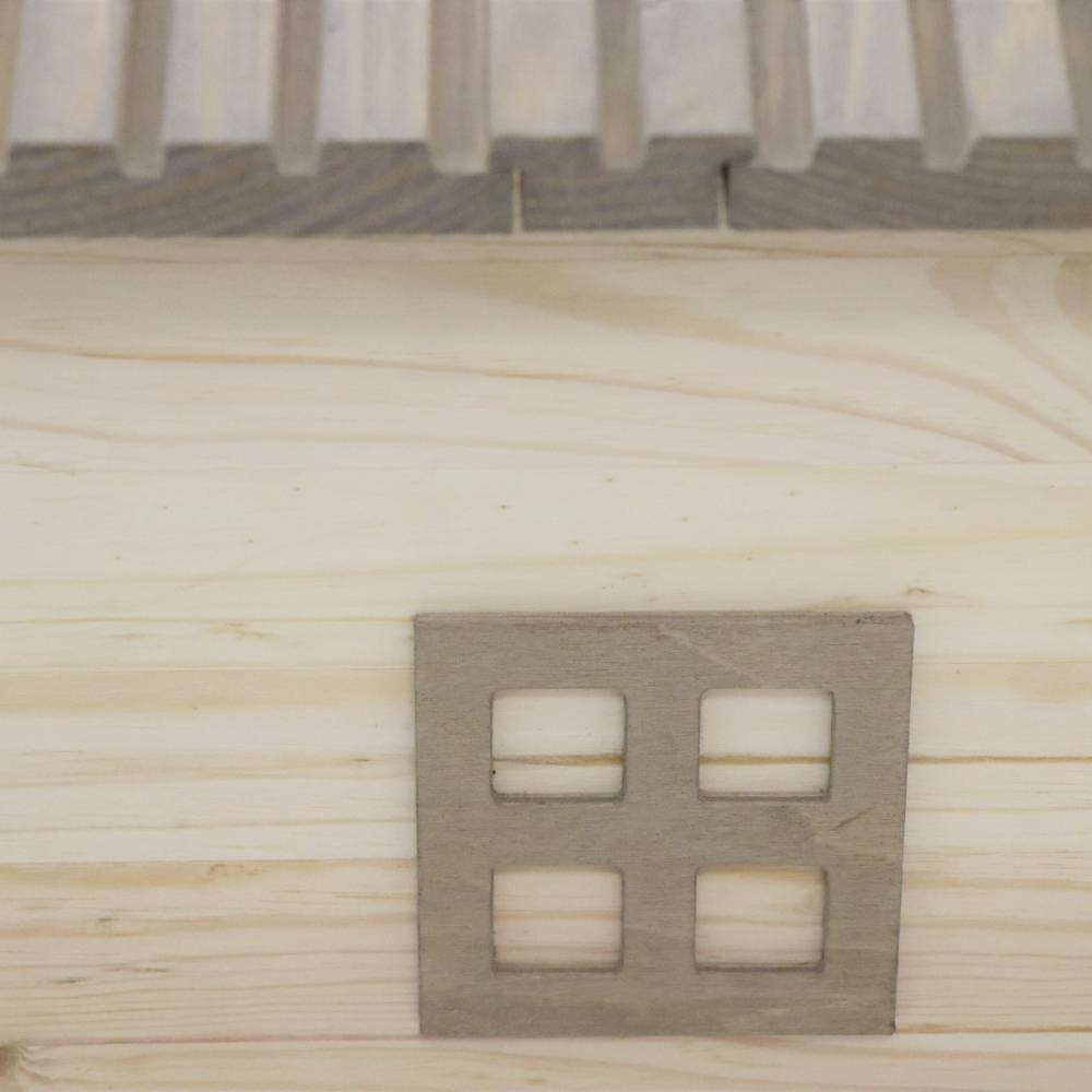 Ein mit Holz verkleideter Eingang mit rechteckigem Ausschnitt und darunter liegendem Holzgitter, vermutlich dekorativ.