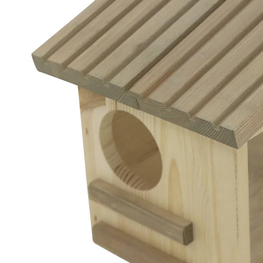 Ein hölzernes Vogelhaus mit einem runden Eingang und einem kleinen Sitzbrett darunter. Es hat ein geneigtes Dach.