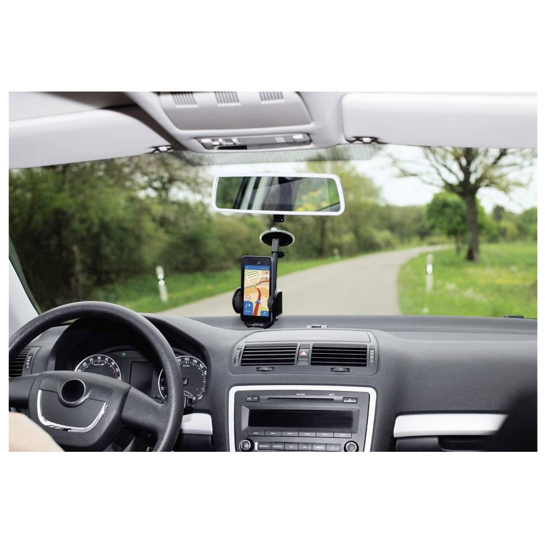 Innenansicht eines Autos, Blick auf eine befestigte Smartphone-Halterung mit Navigations-App auf einer ländlichen Straße.