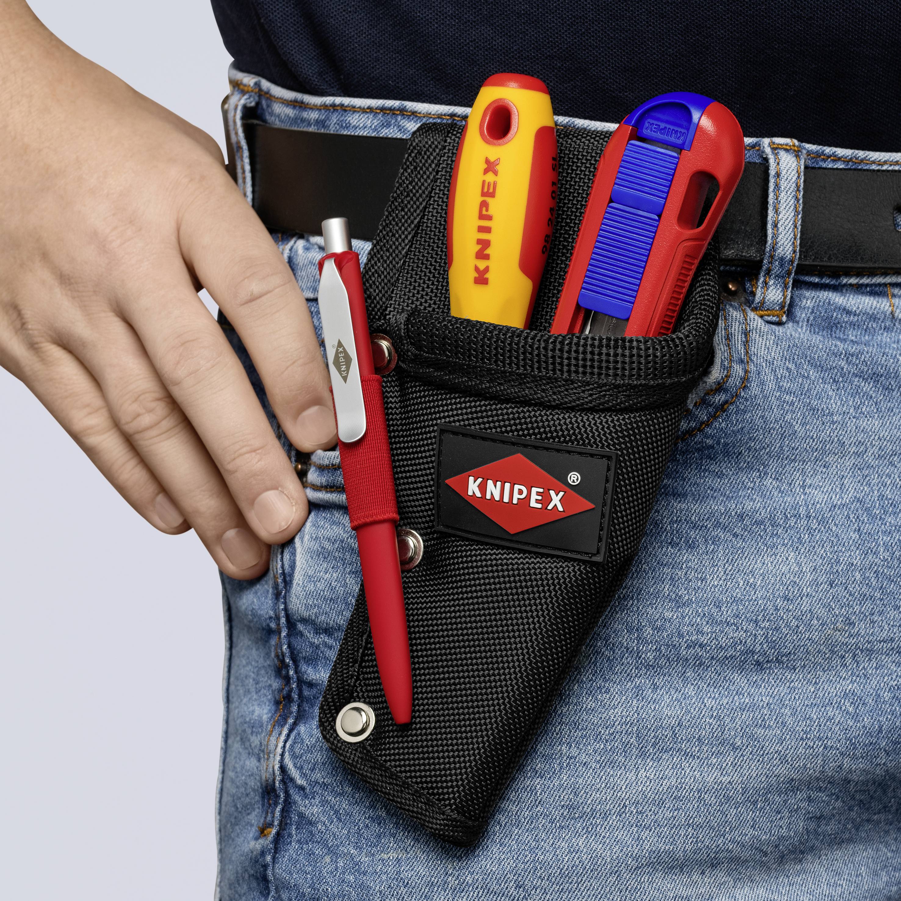 Werkzeugholster am Gürtel mit KNIPEX-Klappmesser, Cuttermesser und Stift, getragen von einer Person in Jeans und dunklem Oberteil.