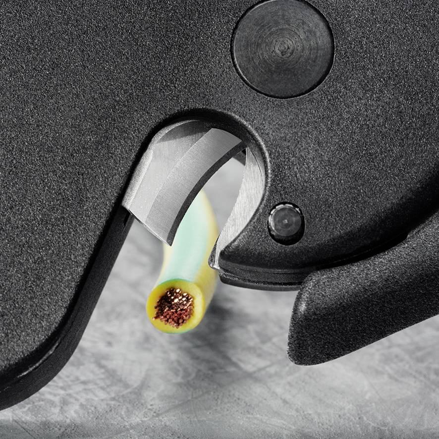 Nahaufnahme eines Kabelschneiders, der ein gelb-grünes Kabel sauber durchtrennt.