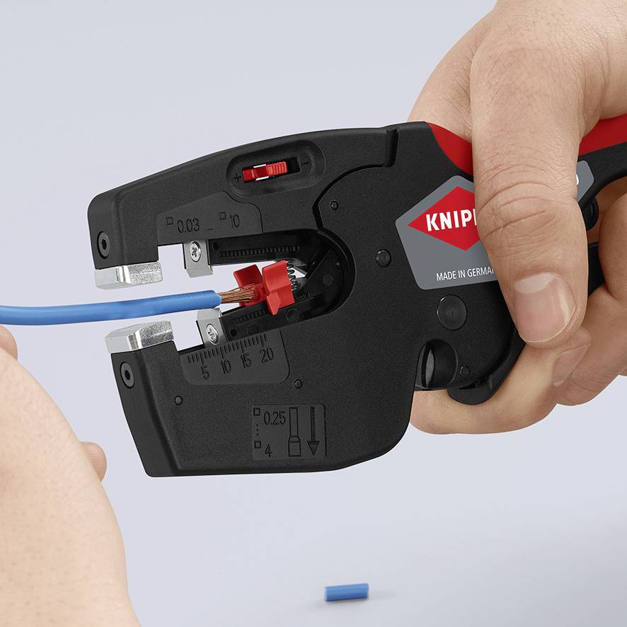 Eine Hand hält eine Abisolierzange, die ein blaues Kabel abisoliert. Das Werkzeug zeigt die Beschriftung 'Knipex'.